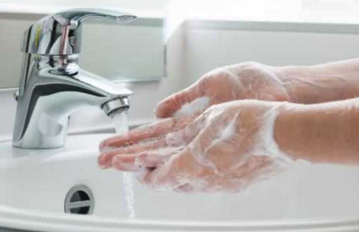 person washing their hands with soap