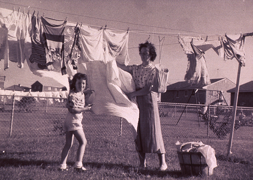 1950s mother and daughter hanging out clothes together