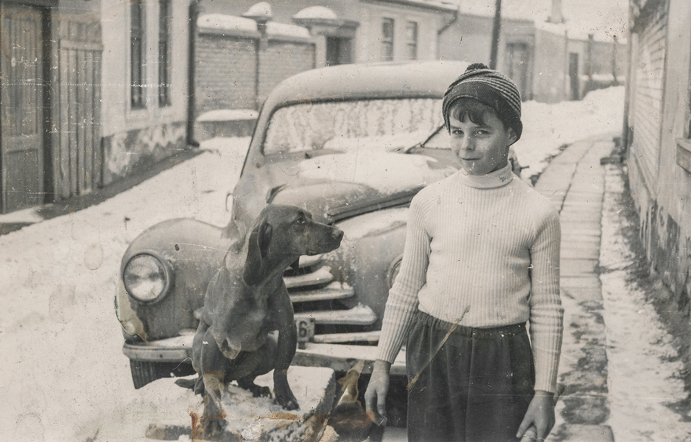 black and white photo of 1940s boy in the snow without a coat