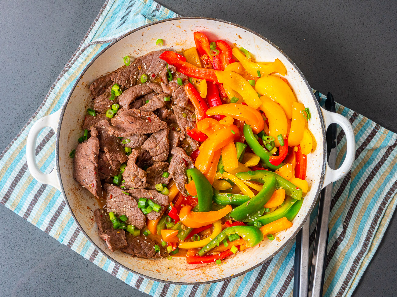 Top down of peppers and steak in a skillet