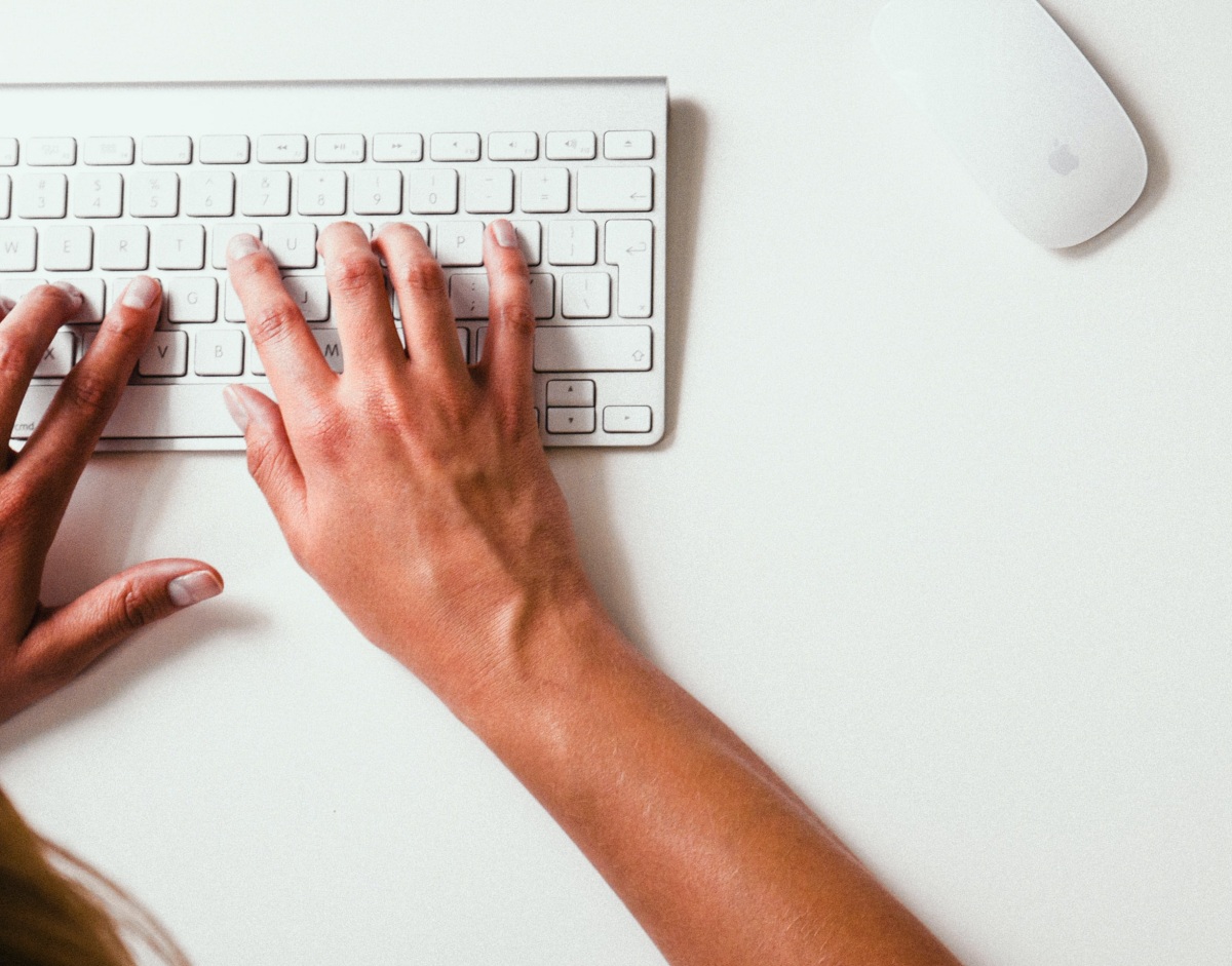 person typing on a Mac keyboard